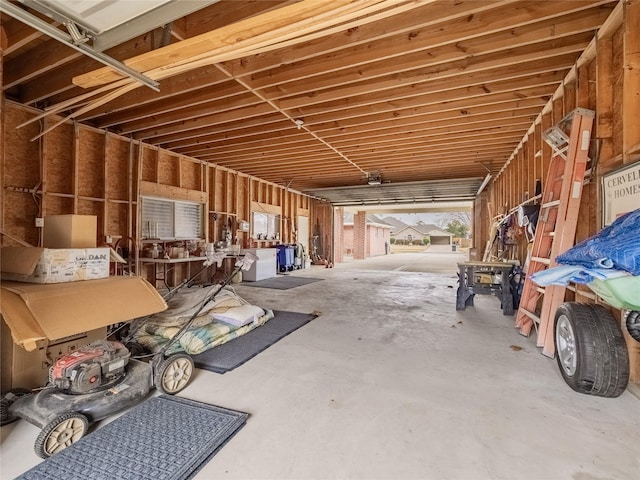 misc room with a garage and unfinished concrete floors