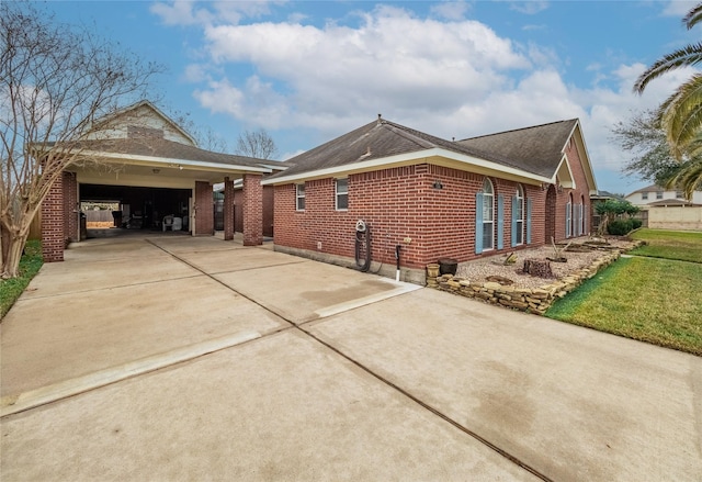 view of home's exterior with a garage, brick siding, and driveway