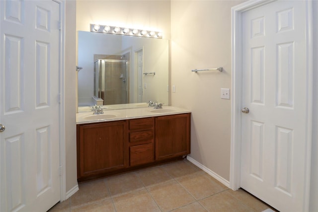 bathroom featuring a shower with door, vanity, and tile patterned floors