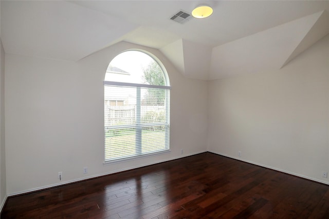 empty room featuring dark wood-type flooring and lofted ceiling