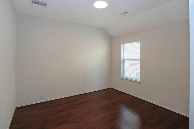 unfurnished room with dark wood-type flooring and vaulted ceiling