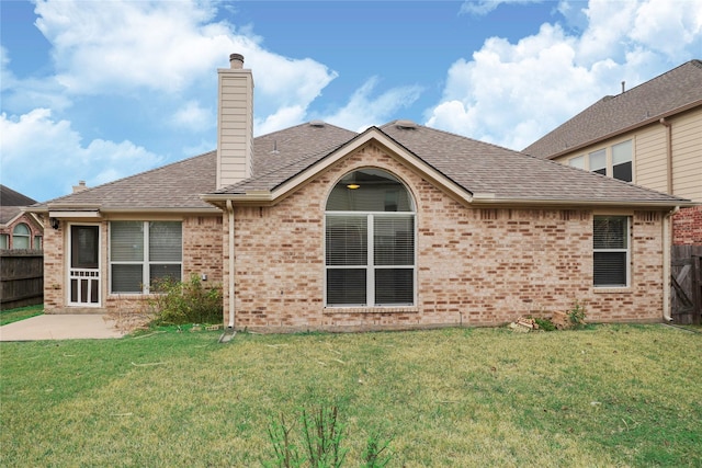 back of house with a patio area and a lawn