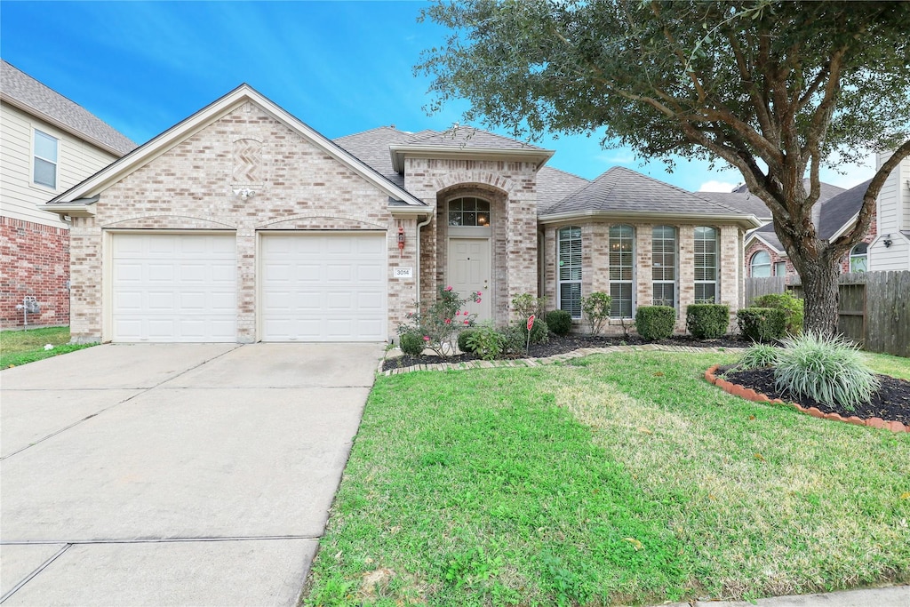 view of front of house with a garage and a front lawn