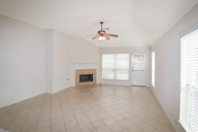 unfurnished living room featuring ceiling fan, lofted ceiling, a fireplace, and light tile patterned floors