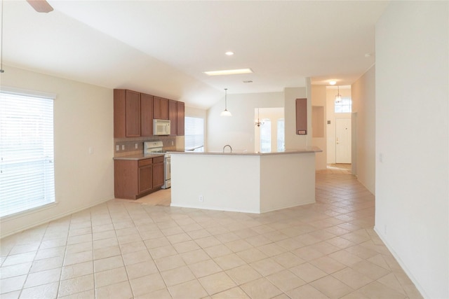 kitchen featuring pendant lighting, an island with sink, lofted ceiling, light tile patterned floors, and white appliances