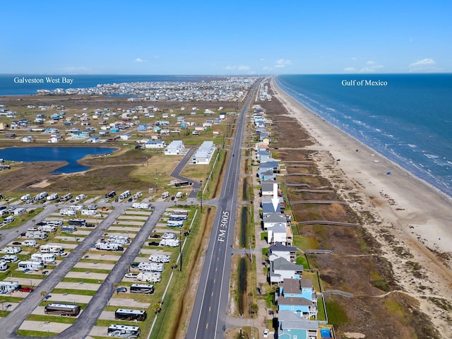 birds eye view of property featuring a water view and a beach view