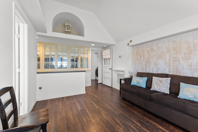 living room featuring vaulted ceiling, washer / dryer, and dark hardwood / wood-style flooring