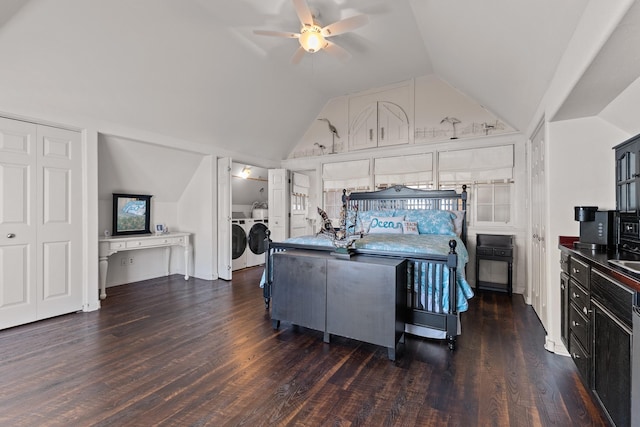 bedroom with dark wood-type flooring, lofted ceiling, and separate washer and dryer