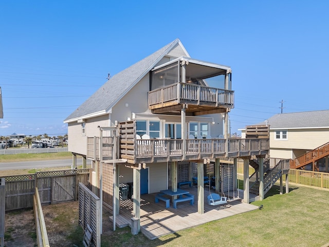 rear view of property featuring a patio, a deck, and a lawn