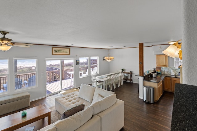 living room with ceiling fan with notable chandelier and dark wood-type flooring