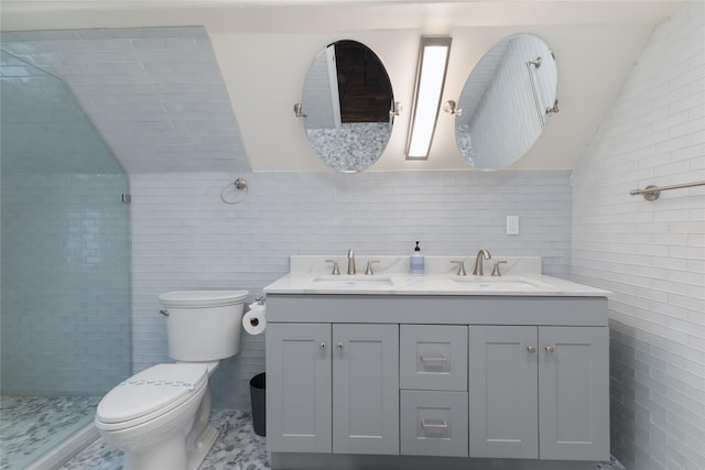 bathroom with tiled shower, toilet, vaulted ceiling, tile walls, and vanity