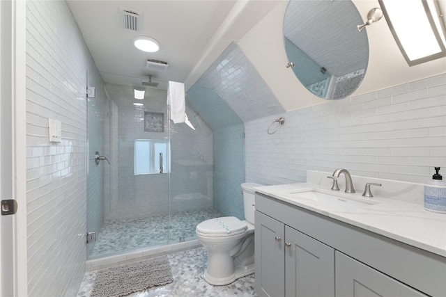 bathroom with vanity, a shower with shower door, toilet, and vaulted ceiling