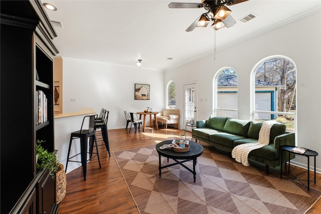 living room with ornamental molding, dark hardwood / wood-style floors, and ceiling fan