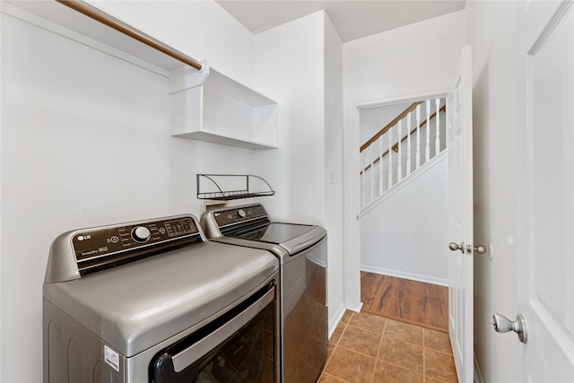 laundry room with independent washer and dryer and light tile patterned floors