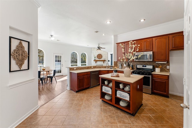 kitchen with a kitchen island, appliances with stainless steel finishes, tasteful backsplash, light tile patterned floors, and kitchen peninsula