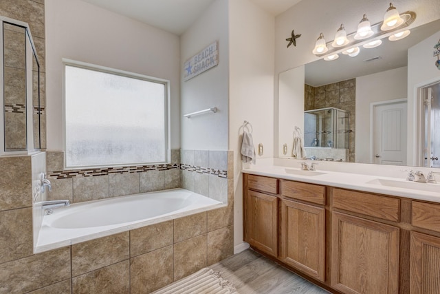 bathroom with vanity, shower with separate bathtub, and wood-type flooring