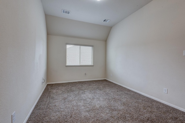 empty room featuring vaulted ceiling and carpet floors