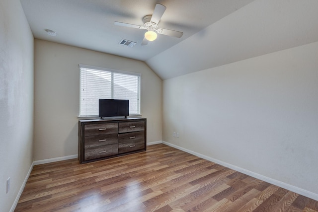 unfurnished bedroom with hardwood / wood-style floors, vaulted ceiling, and ceiling fan