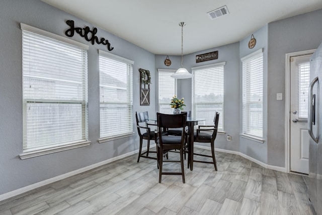 dining room with light hardwood / wood-style floors and a wealth of natural light