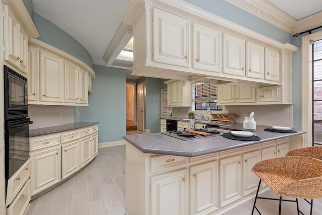 kitchen featuring cream cabinets and black appliances