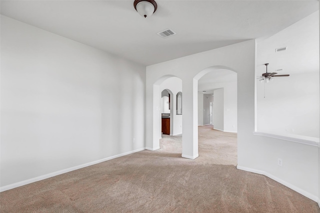 empty room with carpet, visible vents, and baseboards