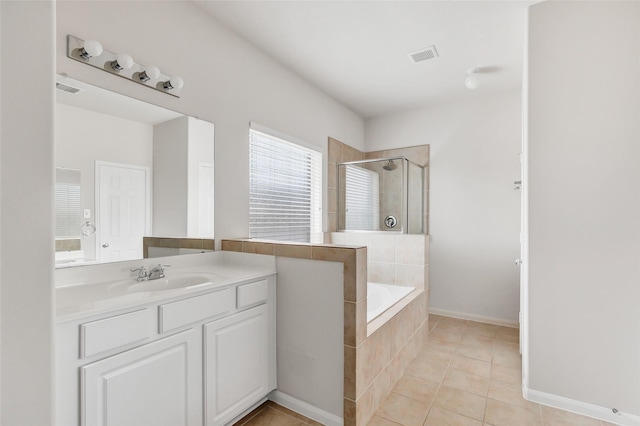 bathroom featuring vanity, visible vents, a bath, tile patterned floors, and a stall shower