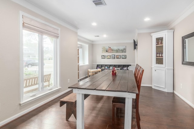 dining area with ornamental molding and dark wood-type flooring