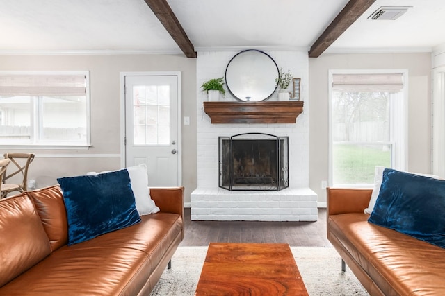 living room featuring beamed ceiling, wood-type flooring, and a fireplace