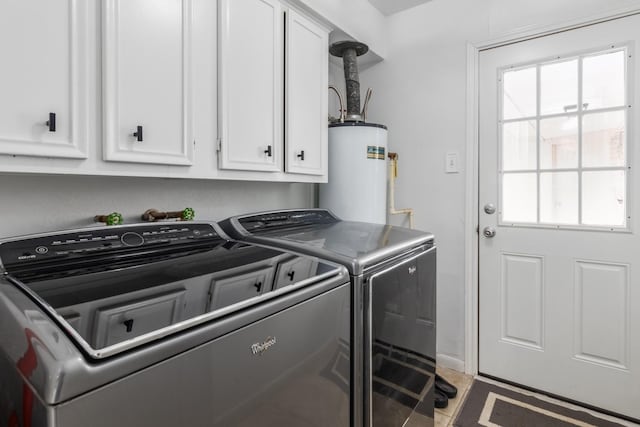 washroom featuring independent washer and dryer, cabinets, and water heater