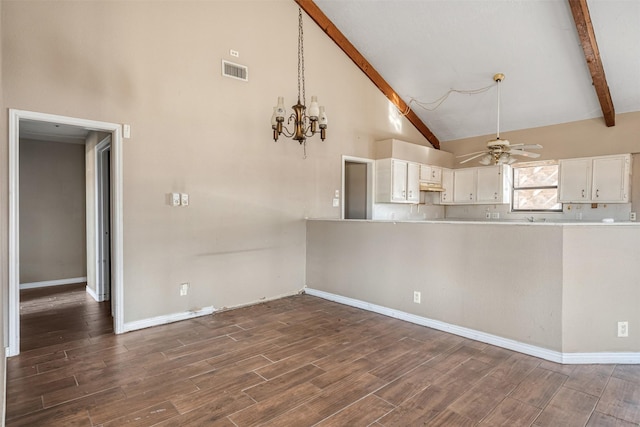 kitchen featuring beam ceiling, ceiling fan with notable chandelier, dark wood-type flooring, and white cabinets