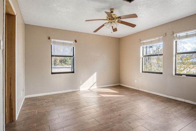 spare room with wood-type flooring, a wealth of natural light, and a textured ceiling