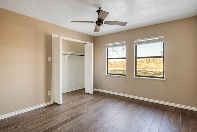 unfurnished bedroom featuring ceiling fan, a textured ceiling, dark hardwood / wood-style flooring, and a closet