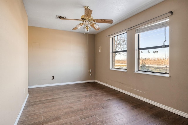 spare room with dark hardwood / wood-style flooring and ceiling fan