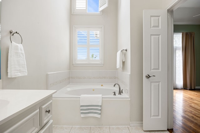 bathroom with a tub to relax in, vanity, tile patterned flooring, and plenty of natural light