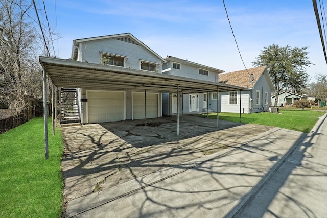 rear view of property featuring a garage and a lawn