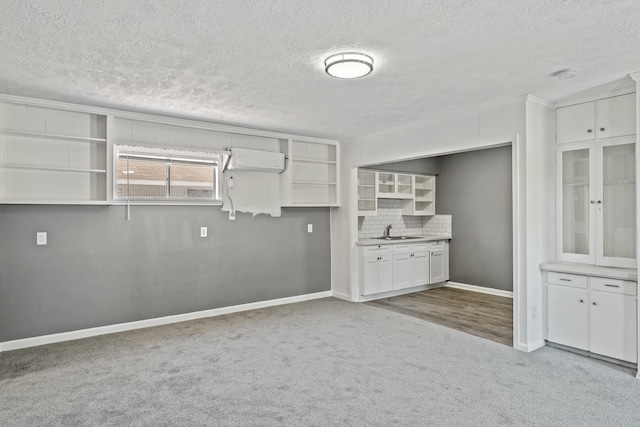 kitchen featuring carpet floors, sink, decorative backsplash, and white cabinets