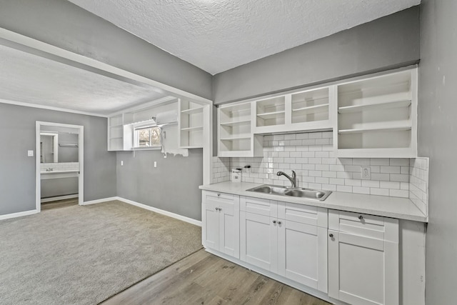 kitchen with sink, backsplash, a textured ceiling, and white cabinets