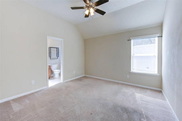 spare room featuring light carpet, vaulted ceiling, and ceiling fan