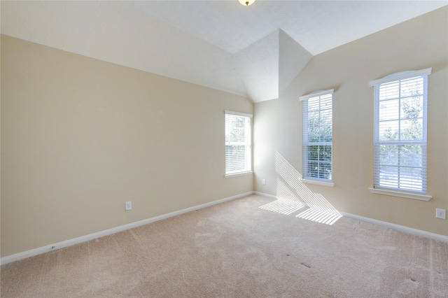 carpeted spare room featuring lofted ceiling