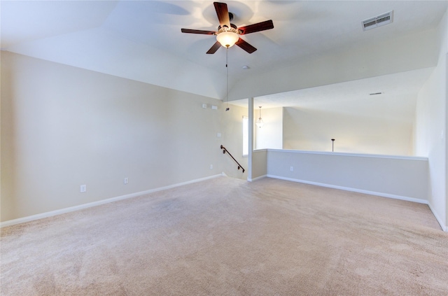 empty room featuring lofted ceiling, light carpet, and ceiling fan