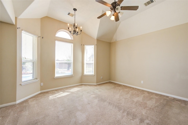 carpeted empty room with lofted ceiling and ceiling fan with notable chandelier