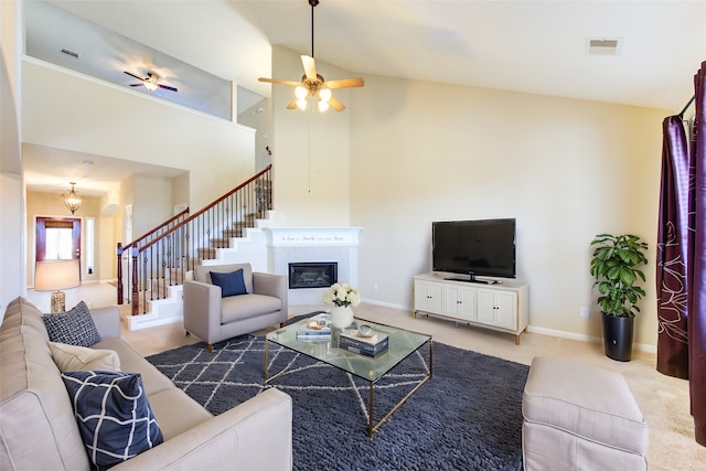 living room featuring a high ceiling, light colored carpet, and ceiling fan