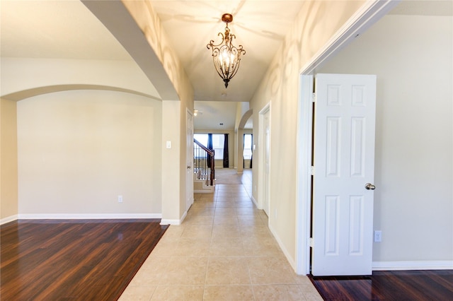 hall with hardwood / wood-style floors and a chandelier