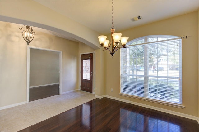 entrance foyer with an inviting chandelier and wood-type flooring