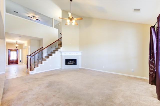 unfurnished living room featuring high vaulted ceiling, a fireplace, ceiling fan with notable chandelier, and light carpet