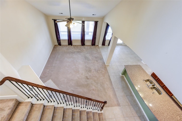 stairway featuring ceiling fan and tile patterned floors