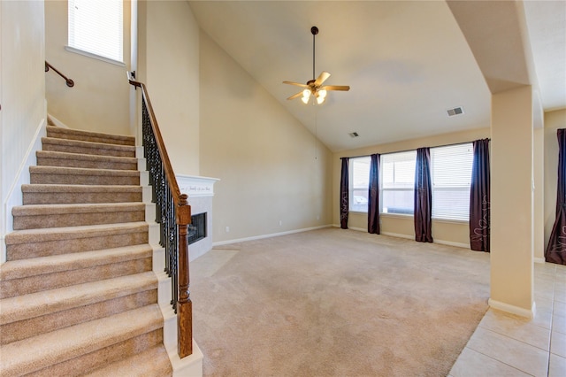 interior space with high vaulted ceiling, ceiling fan, and carpet