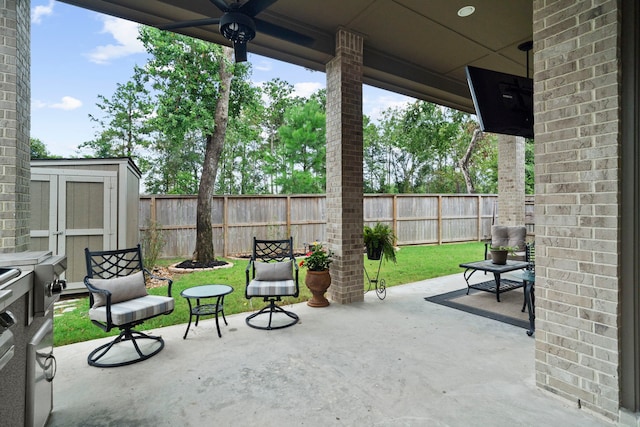 view of patio with ceiling fan and a storage unit