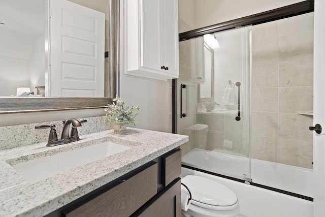 full bathroom with vanity, combined bath / shower with glass door, and toilet