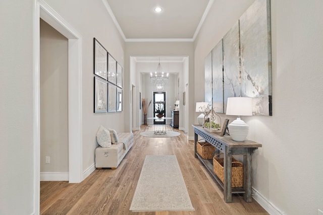 interior space with crown molding, light hardwood / wood-style floors, and a chandelier